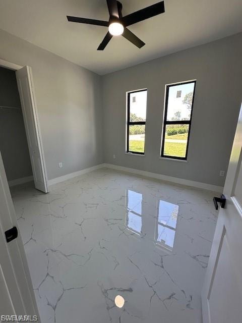 Unfurnished bedroom featuring light marble finish flooring and a ceiling fan