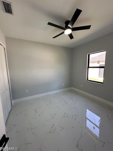 Unfurnished bedroom with ceiling fan, a closet, and light marble finish floors
