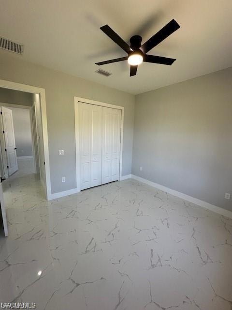 Unfurnished bedroom with light marble finish floors, a closet, and ceiling fan