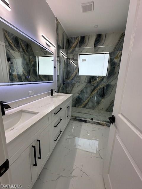 Bathroom featuring double vanity, a marble finish shower, and light marble finish flooring