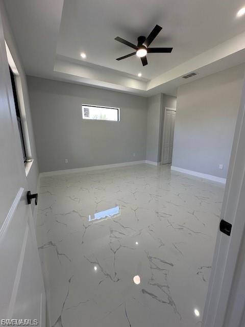 Unfurnished room with recessed lighting, a ceiling fan, a raised ceiling, and light marble finish flooring