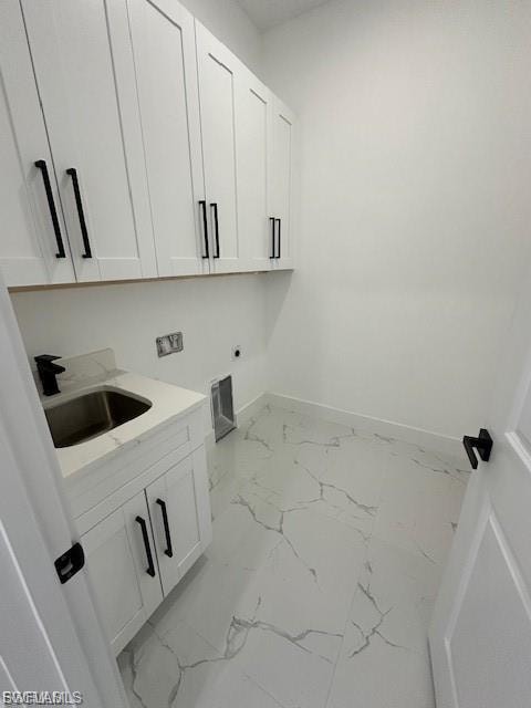 Laundry room featuring cabinet space, light marble finish flooring, and electric dryer hookup