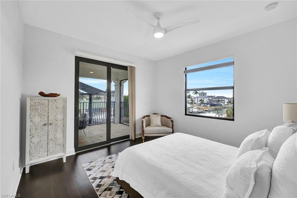 Bedroom featuring access to exterior, dark wood-type flooring, ceiling fan, and multiple windows