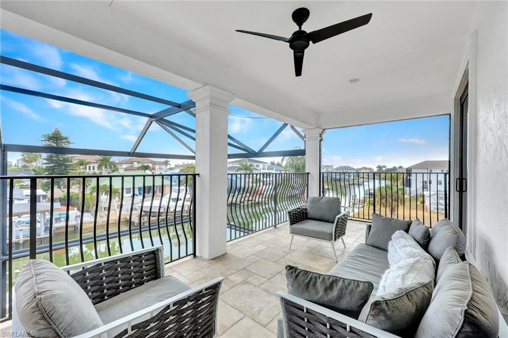 View of patio / terrace with outdoor lounge area, ceiling fan, a sunroom, a water view, and a residential view