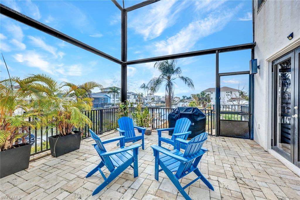 View of patio featuring a sunroom, a residential view, and area for grilling