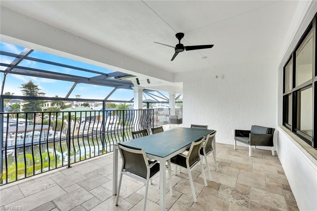 View of patio / terrace with ceiling fan, outdoor dining space, and glass enclosure