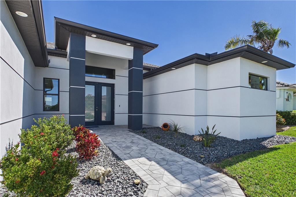 View of exterior entry featuring french doors and stucco siding