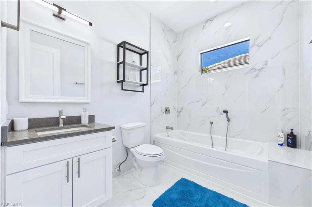Full bathroom with vanity and light marble finish floors