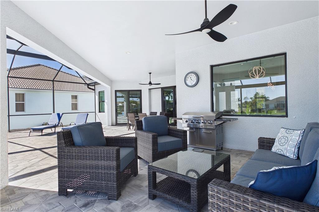 View of patio with a sunroom, a ceiling fan, a lanai, area for grilling, and an outdoor living / dining area