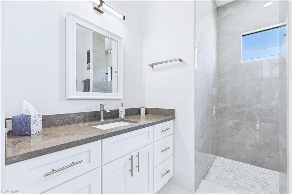 Full bathroom with a marble finish shower and vanity