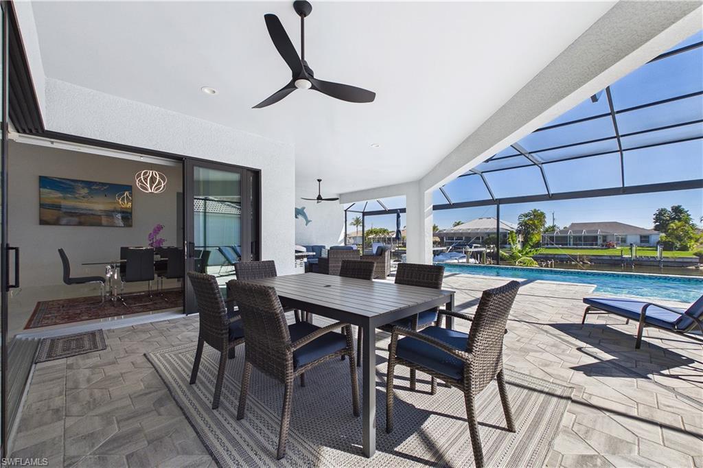 View of patio featuring an outdoor pool, outdoor dining space, a sunroom, a lanai, and a ceiling fan