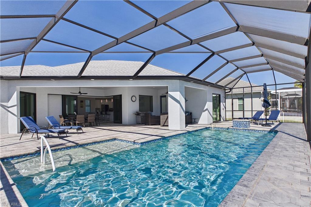 Outdoor pool featuring a sunroom, a patio, and a lanai
