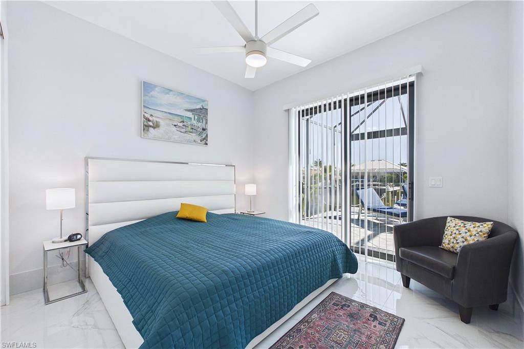 Bedroom featuring access to outside, marble finish floors, and ceiling fan