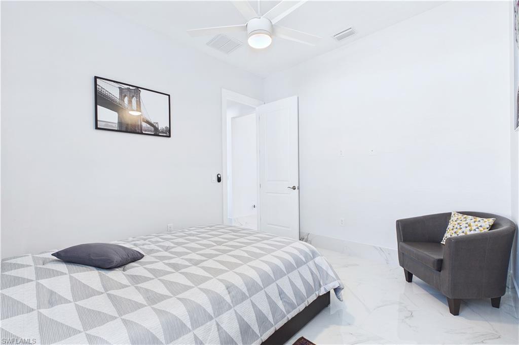 Bedroom with ceiling fan and marble finish floors