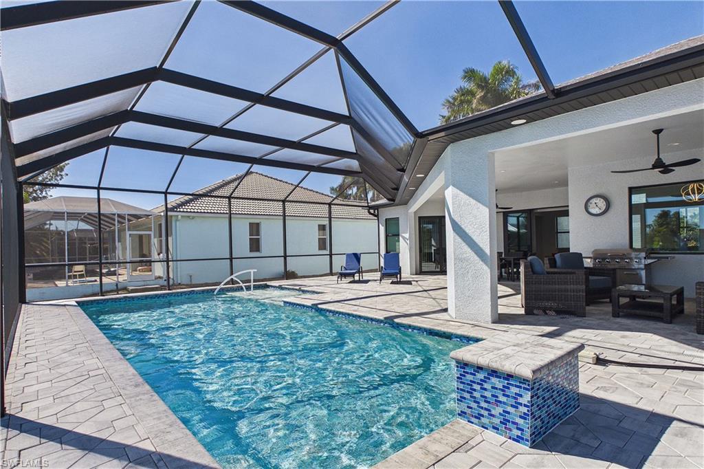 Swimming pool featuring a sunroom, a patio area, and glass enclosure