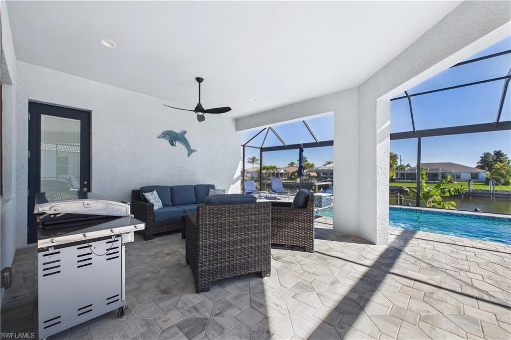 View of patio featuring an outdoor lounge area, a sunroom, a lanai, ceiling fan, and an outdoor pool