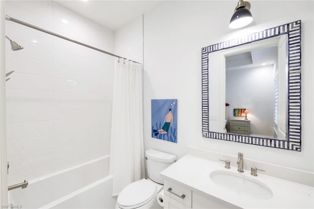 Bathroom featuring vanity and shower / bath combination with curtain