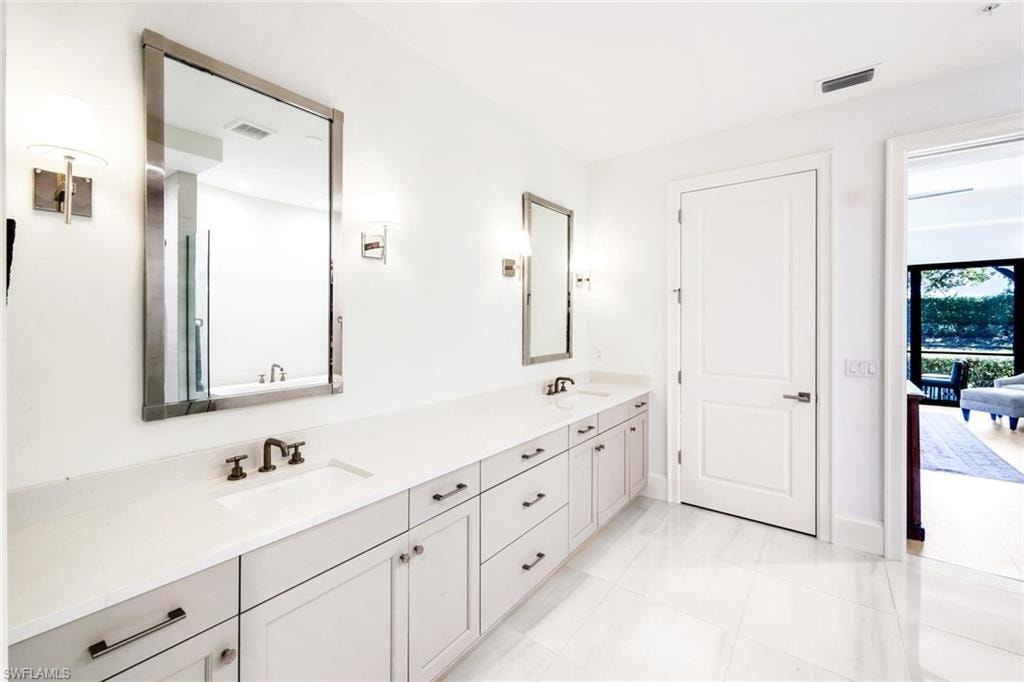 Bathroom featuring double vanity and light tile patterned flooring