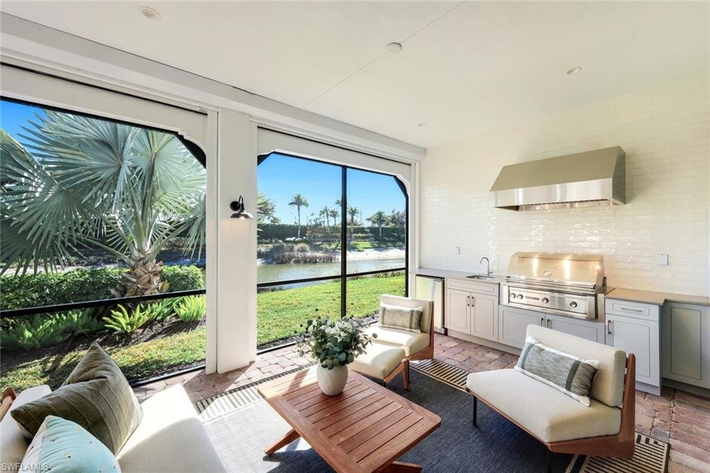 Sunroom / solarium with an outdoor kitchen with living area, a water view, and a patio area