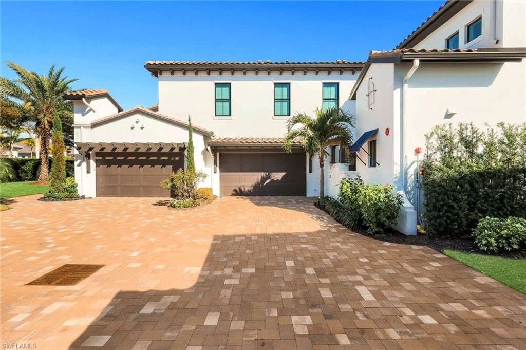 Mediterranean / spanish home with stucco siding, decorative driveway, and a garage