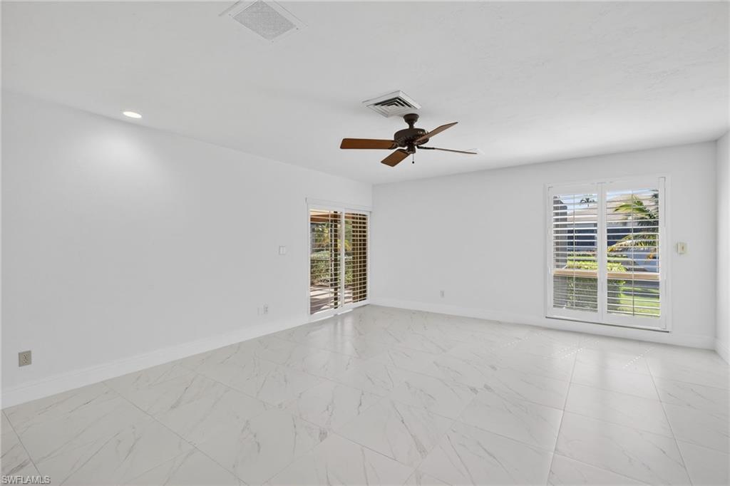 Spare room with light marble finish flooring and a ceiling fan