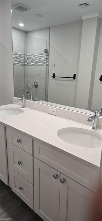 Full bath featuring double vanity and a stall shower