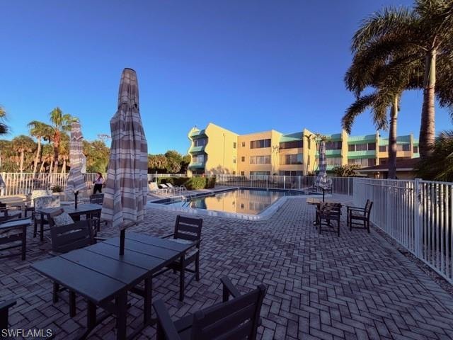 View of patio / terrace with a community pool and outdoor dining area