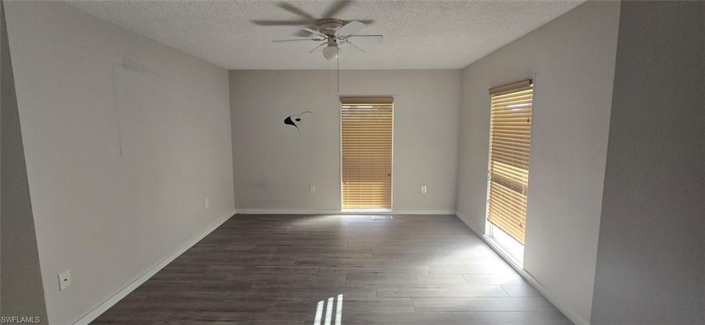 Unfurnished bedroom with dark wood-style floors, ceiling fan, and a textured ceiling