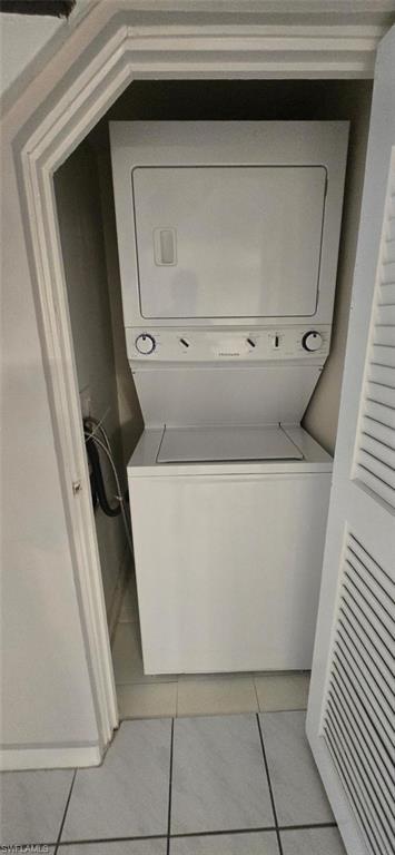 Laundry area featuring stacked washer / dryer and light tile patterned floors