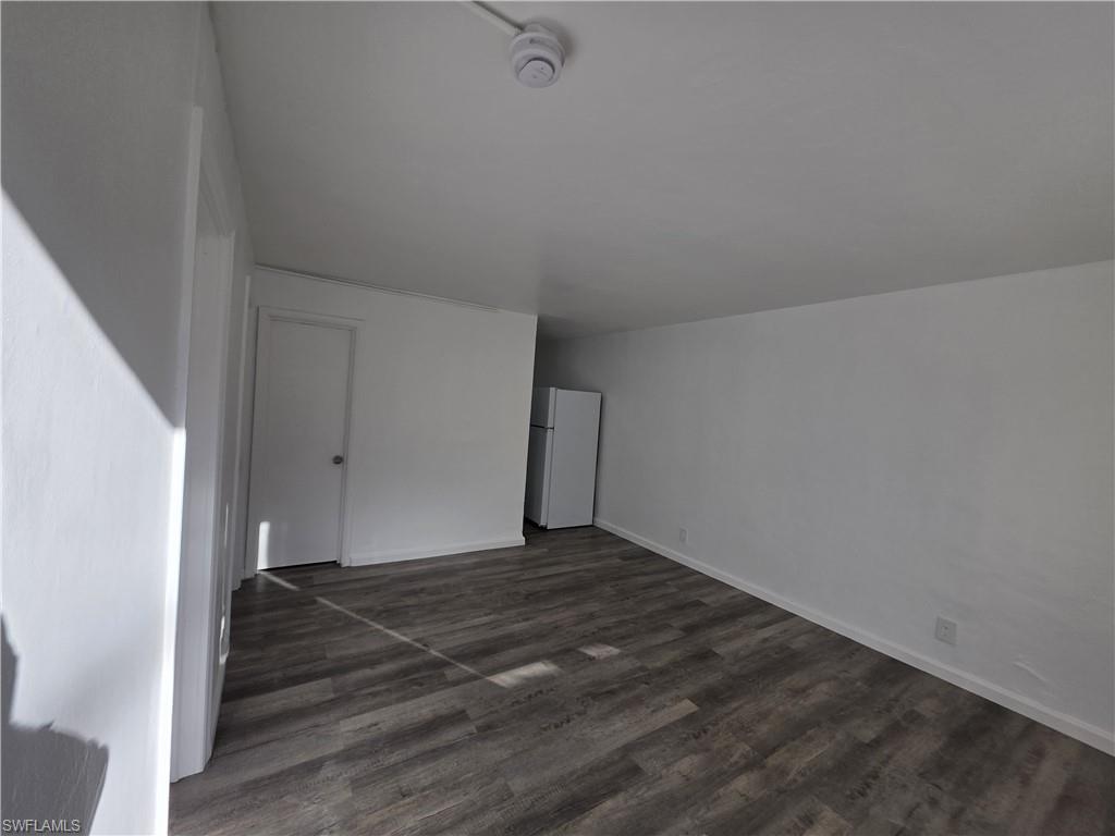 Additional living space featuring dark wood-style floors