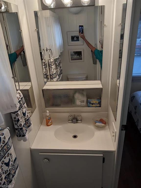 Half bathroom featuring vanity and toilet