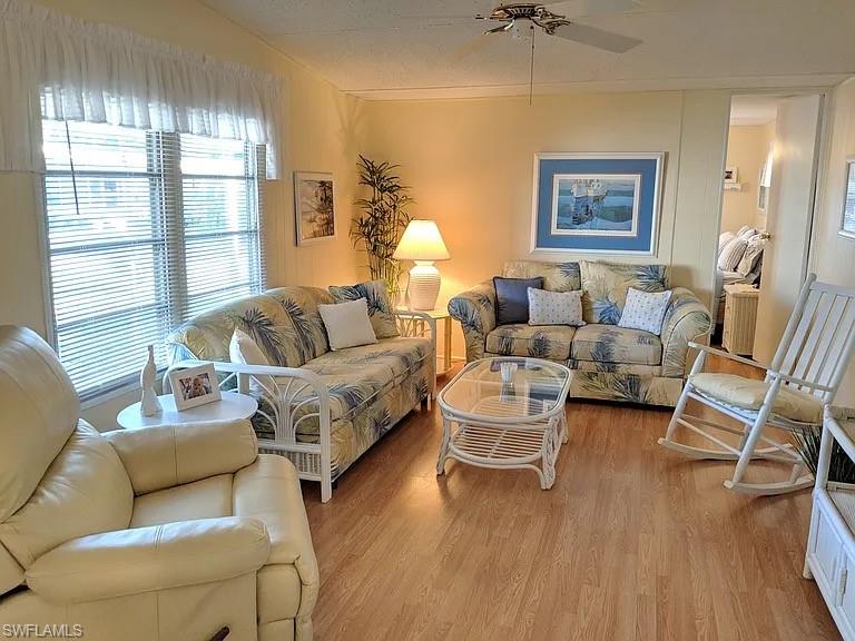 Living room with wood finished floors and a ceiling fan