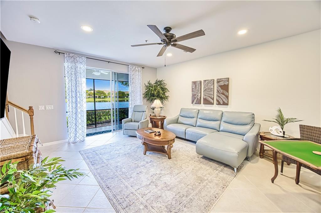 Living area featuring a ceiling fan, a water view, light tile patterned floors, and recessed lighting
