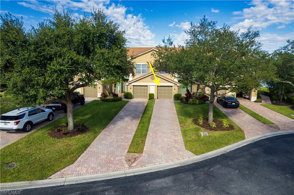 Obstructed view of property with decorative driveway, a front lawn, and a garage