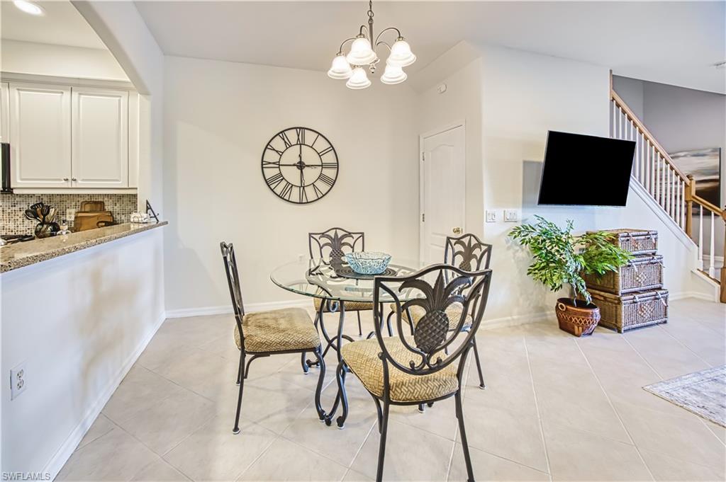 Dining space with suspended lighting and light tile patterned floors