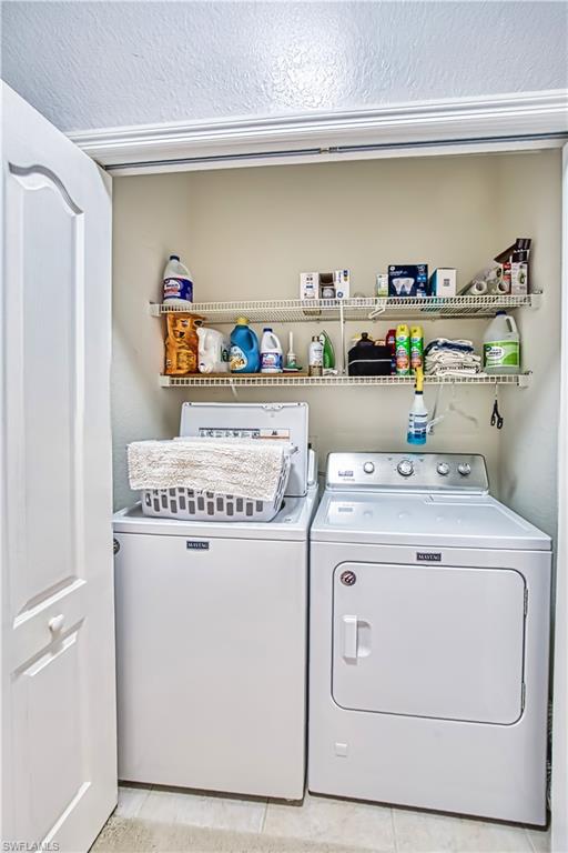 Laundry area with washer and dryer and a textured ceiling