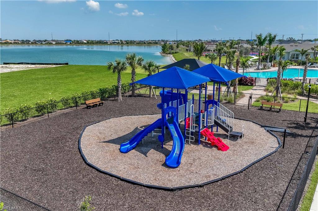 Playground with multiple slides, shade canopies, and a rubberized surface