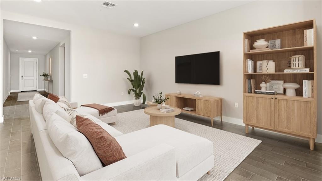 Recessed lighting throughout, wood-finish flooring, light-toned walls, and a white interior door