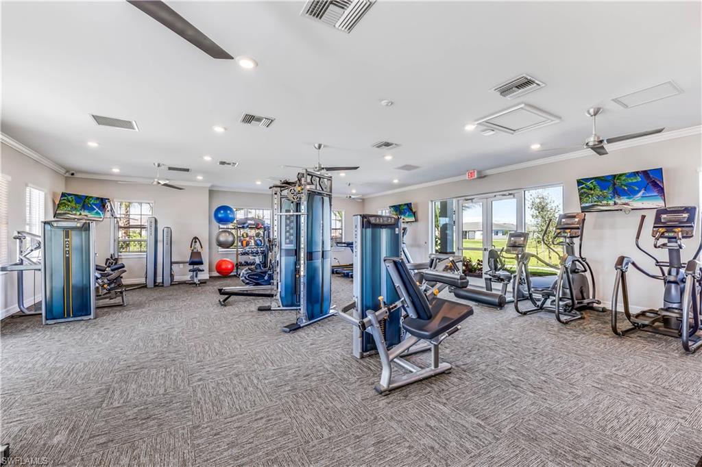 Fitness center with multiple exercise stations, ceiling fans, recessed lighting, and large windows