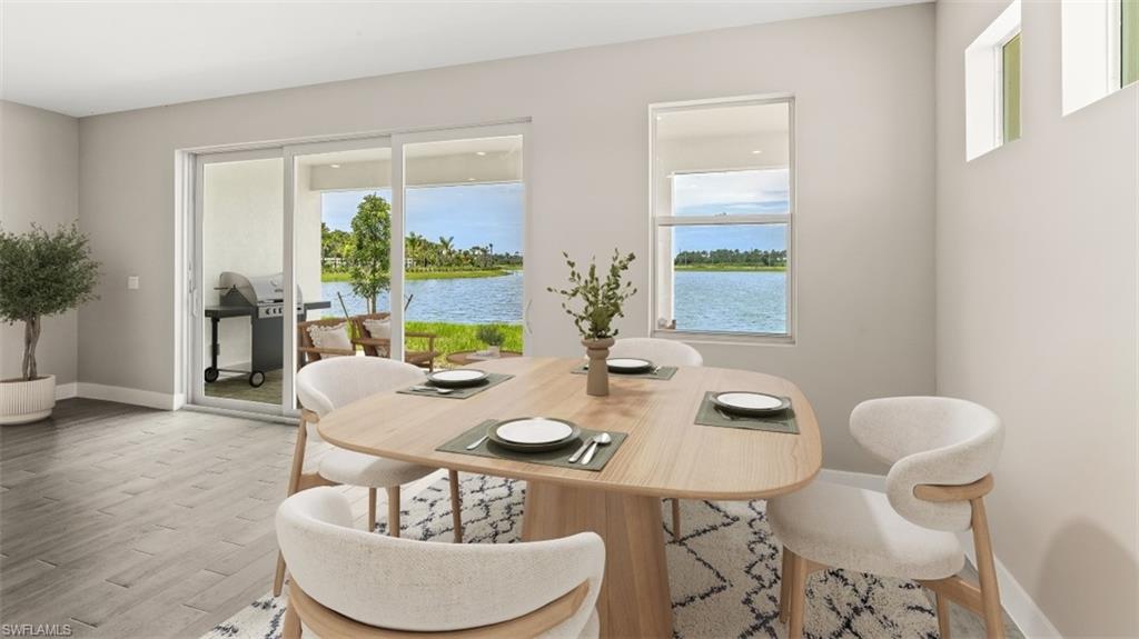 Sliding glass doors opening to a covered patio, water body beyond, and wood-finish flooring