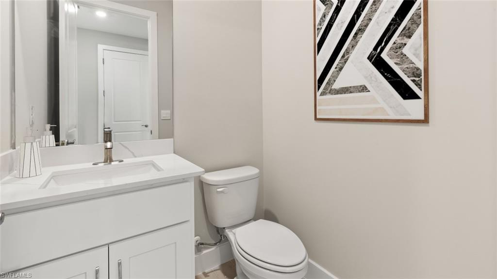 White vanity with a single basin sink, brushed nickel faucet, and integrated countertop