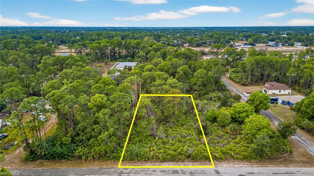 Aerial overview of property's location with property boundaries highlighted and a heavily wooded area