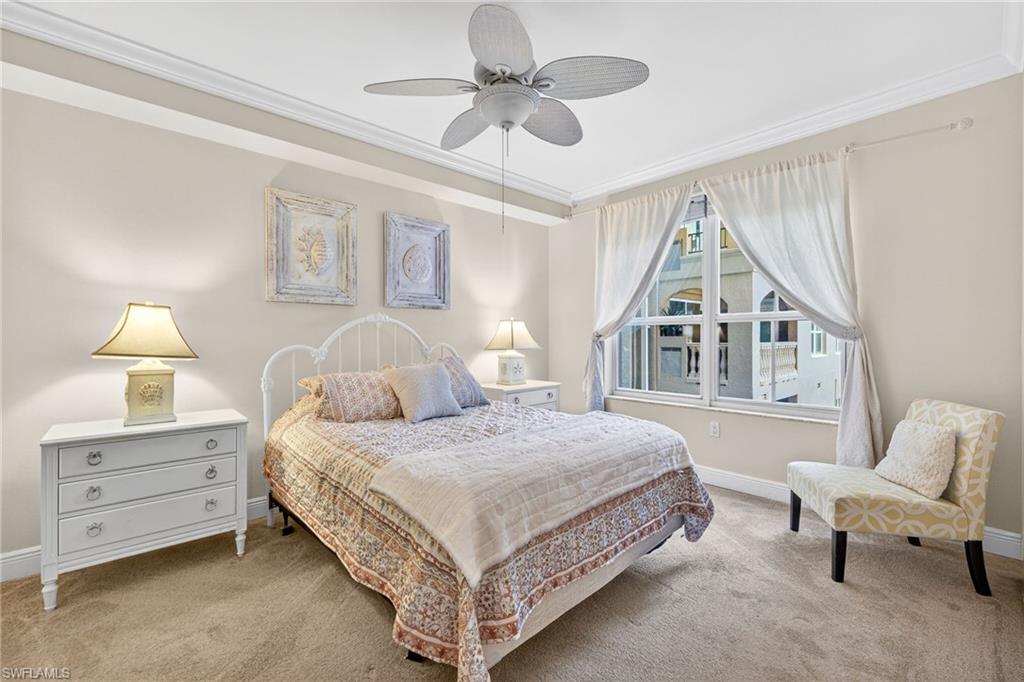 Carpeted bedroom with crown molding and ceiling fan
