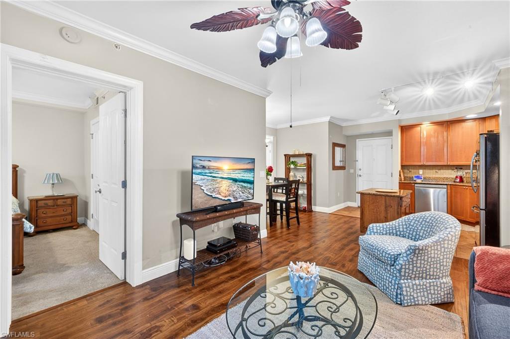 Living area with crown molding, light wood-style floors, a ceiling fan, and rail lighting
