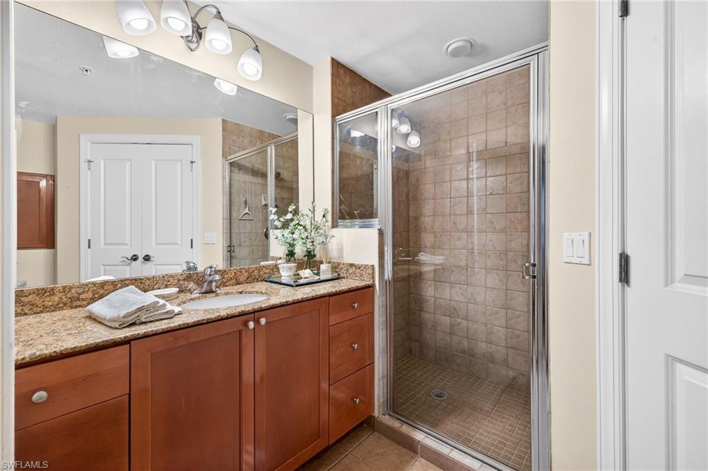 Bathroom featuring vanity, a shower stall, and light tile patterned floors
