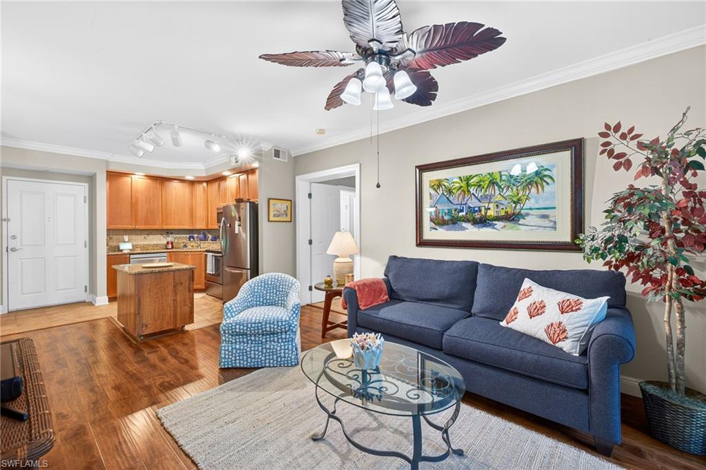 Living area featuring ornamental molding, light wood-style floors, a ceiling fan, and rail lighting