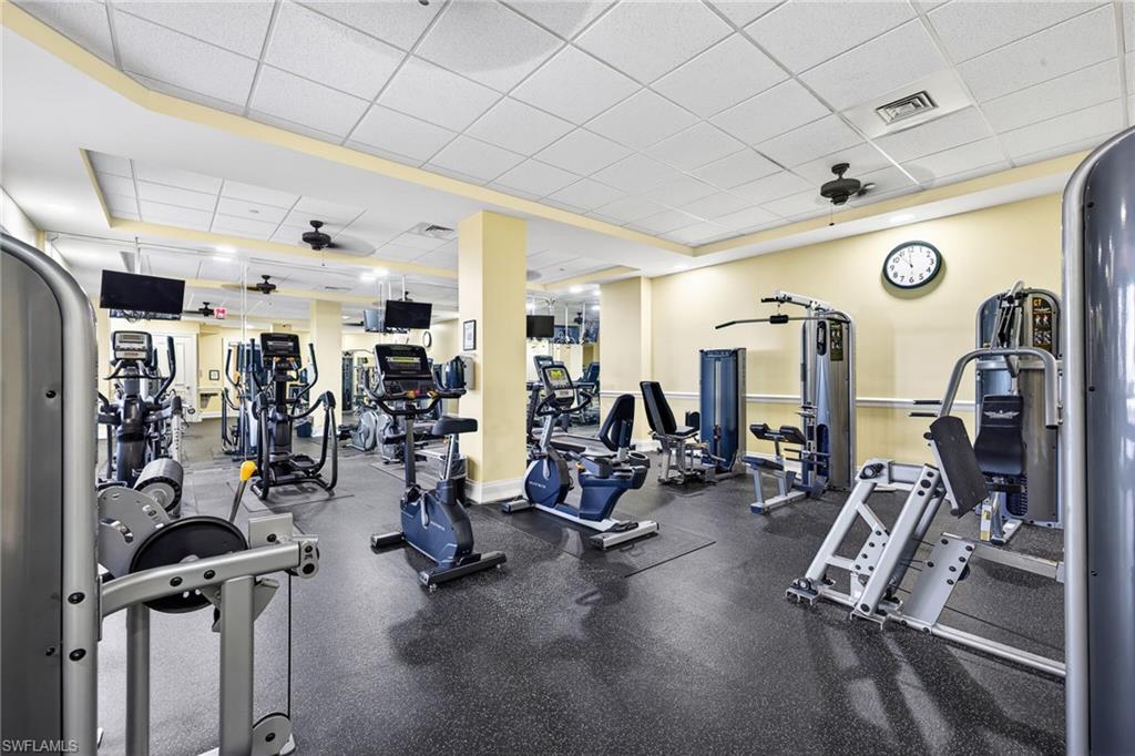 Exercise room with ceiling fan and a drop ceiling