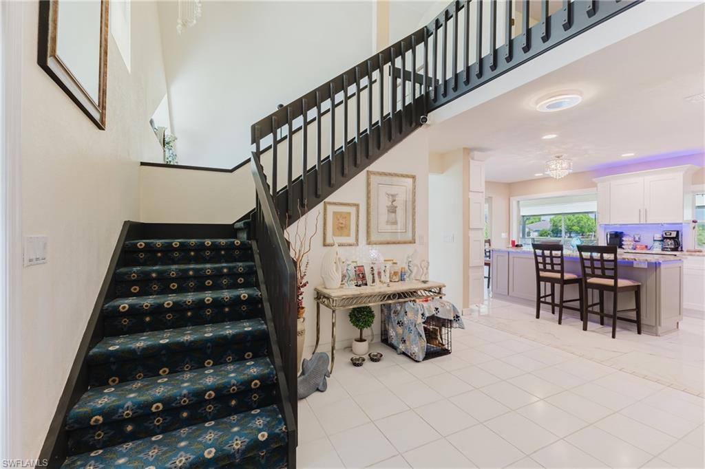 Stairs with a high ceiling and tile patterned flooring