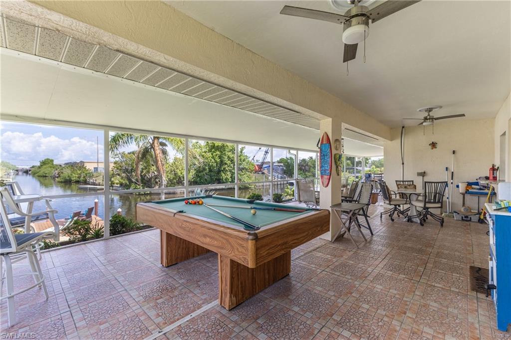 Playroom featuring billiards table, a ceiling fan, and a water view