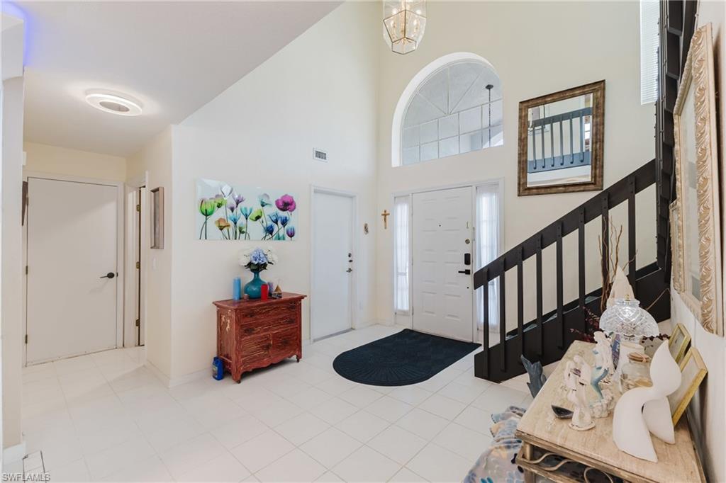 Tiled entryway featuring a high ceiling and stairway
